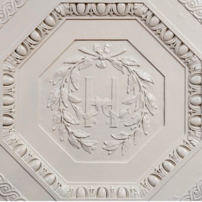 Photograph of decorative white plaster tile in Harvard Club NYC on Ronnie Stangler MD media and events page regarding presentation by Dr. Stangler for Prestel and Partner NYC Family Office Forum on Genomics and Its Impact on Families of Wealth.