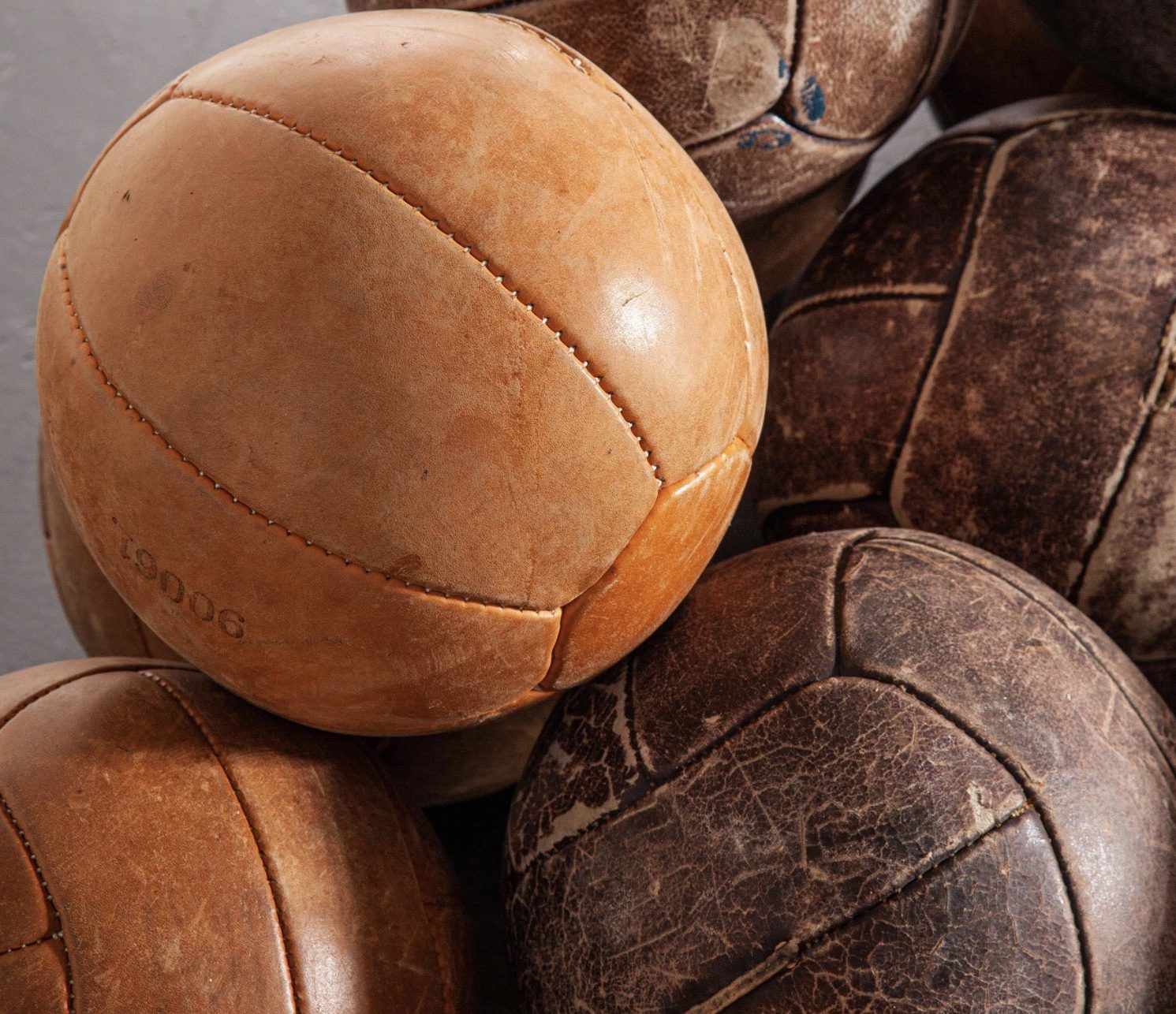 Multiple vintage leather weight balls used for exercise on Ronnie Stangler MD good reads page regarding Pumping Iron and Longevity in Older Adults.