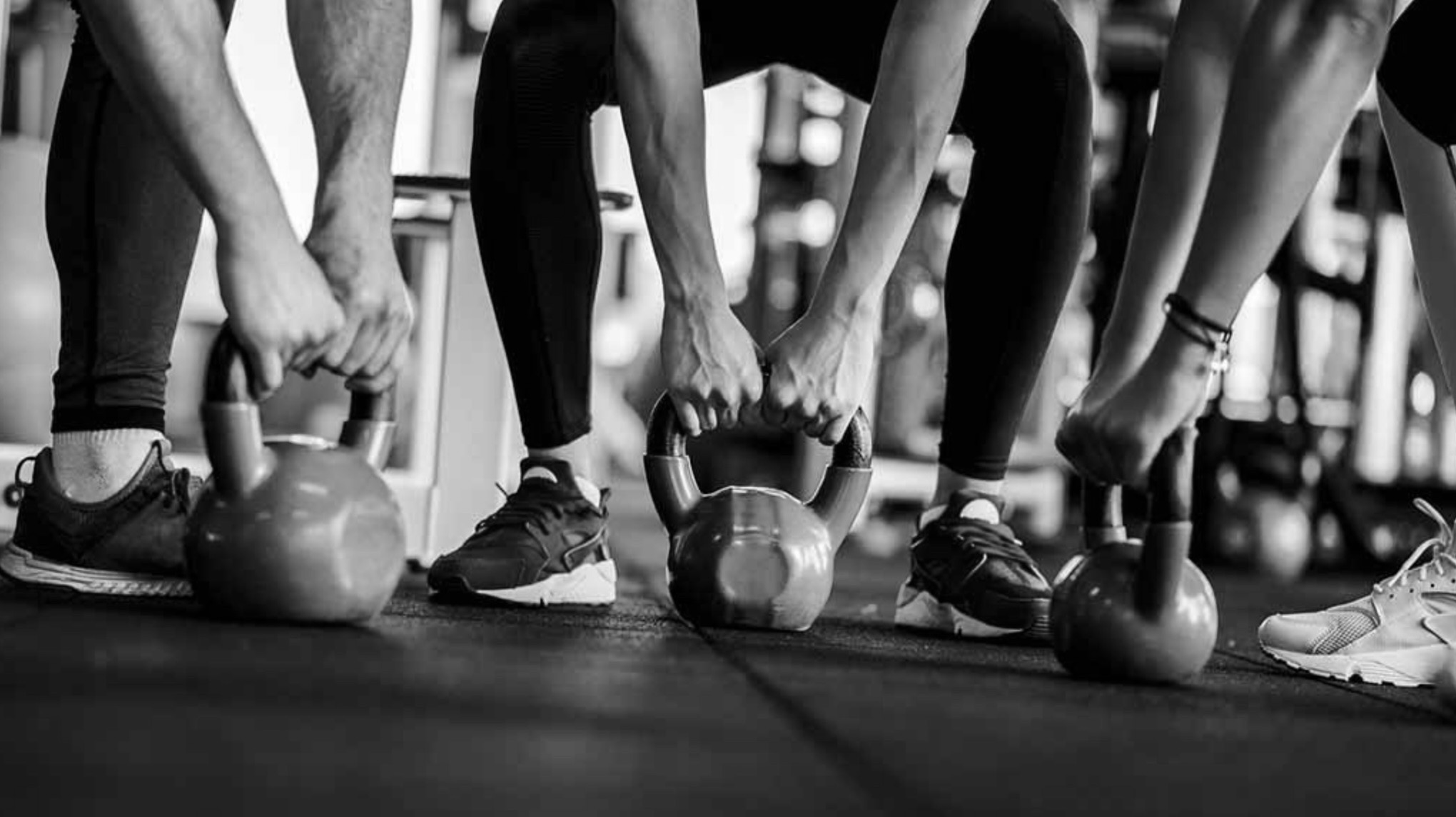 Black and white photographs of hands holding kettlebells on floor in Ronnie Stangler MD good reads page regarding Exercise Motivation and Your Microbiome.